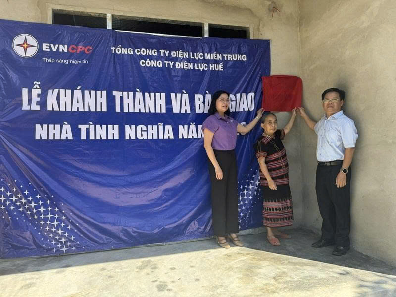 Nghi thức kéo băng đỏ bàn giao nhà tình nghĩa cho bà Lê Thị Lương. Ảnh: D. Huyền