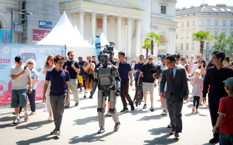 VR-H3 của VinRobotics thu hút sự chú ý với khả năng di chuyển tự nhiên tại Festival der Roboter 2026 ở Vienna, dưới sự chứng kiến của Đại sứ Việt Nam tại Áo, ông Vũ Lê Thái Hoàng (thứ hai từ phải sang, hàng trên), cùng đông đảo khách tham quan quốc tế. Nguồn: VinRobotics