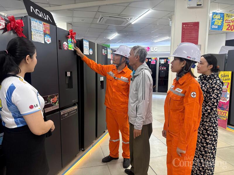 Ông Nguyễn Văn Thắng được cán bộ ngành điện và nhân viên Điện máy Xanh tư vấn lựa chọn tủ lạnh có dán nhãn năng lượng. Ảnh: Cao Thảo