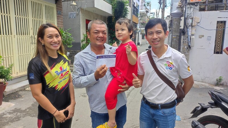 Em bé và cha hào hứng và vui mừng khi nhận quà Tết Thiếu nhi từ Công ty Tân Hiệp Phát.