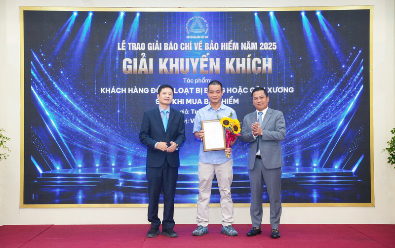 Ông Nguyễn Phong Cầm (phải), Phó Tổng Thư ký Hiệp hội Bảo hiểm Việt Nam, Tổng Biên tập Tạp chí Tài chính Bảo hiểm cùng đại diện Ban tổ chức trao giải Khuyến khích cho tác phẩm "Khách hàng đồng loạt bị bỏng hoặc gãy xương sau khi mua bảo hiểm" của tác giả Tuân Nguyễn, Báo VietnamNet. Ảnh: Ban tổ chức