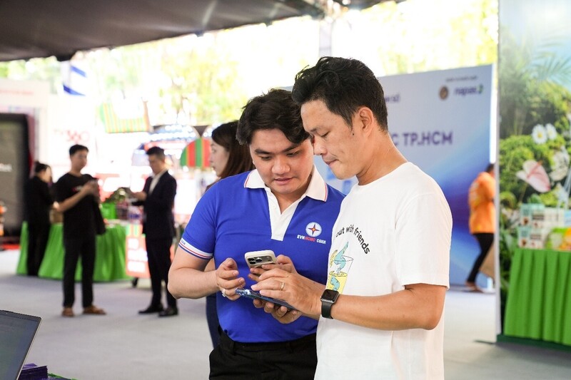 Nhân viên EVNHCMC hướng dẫn khách hàng cài đặt và trải nghiệm ứng dụng EVNHCMC. Ảnh: EVNHCMC