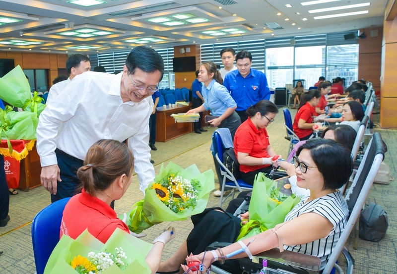 Phó Bí thư Thường trực Đảng ủy Petrovietnam Trần Quang Dũng tặng hoa động viên người lao động và cán bộ y tế tham gia Ngày hội hiến máu tình nguyện "Nhiệt huyết Petrovietnam" năm 2026. Ảnh: Petrovietnam