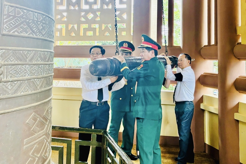 Phó Thủ tướng Hồ Quốc Dũng thực hiện nghi lễ thỉnh chuông khai lễ truy điệu và an táng hài cốt liệt sĩ. Ảnh: Ngọc Minh