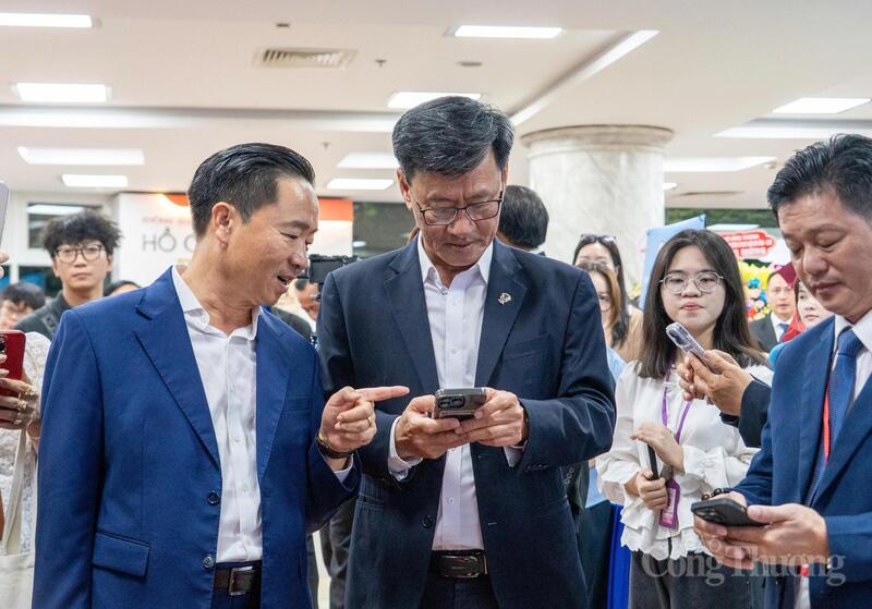 Ông Trần Văn Chín - Chủ tịch Arobid.com (người bên trái) giới thiệu nền tảng xúc tiến thương mại số TBSG Business Hub với các đại biểu bên lề sự kiện.