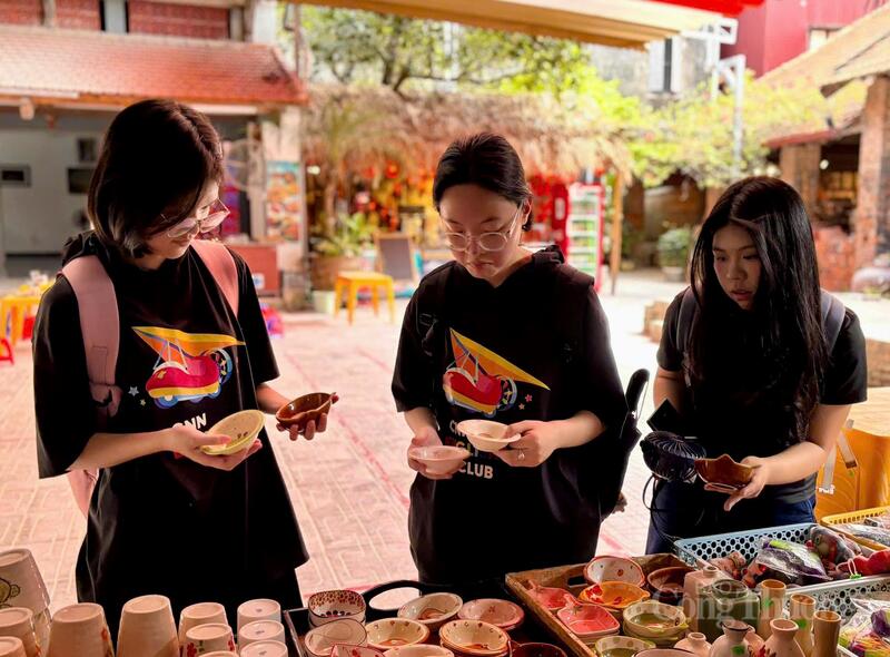 Các bạn trẻ đến với làng nghề để tham quan, mua sắm các sản phẩm gốm sứ tại làng nghề. Ảnh: Nhật Chi