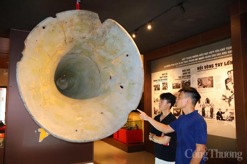 Bạn Phí Công Mạnh (áo xanh) bên phải chăm chú ngắm nhìn hiện vật. Ảnh: Phương Hà