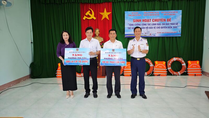 Vùng Cảnh sát biển 2 tặng cờ Tổ quốc, phao cứu sinh cho phường Trà Câu. Ảnh: Nam Trung