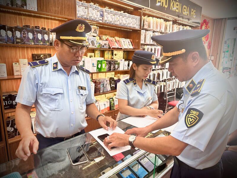 Quản lý thị trường tỉnh Cà Mau kiểm tra hộ kinh doanh điện thoại di động nhưng không xuất trình được hóa đơn, chứng từ chứng minh tính hợp pháp của hàng hóa. Ảnh: DSM Cà Mau