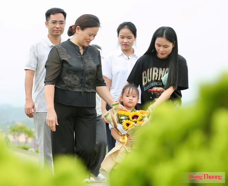 Từ sáng sớm, bà Hằng cùng con, cháu thành kính dâng hương trước phần mộ người thân trong ngày Gia Đình Việt Nam. Ảnh: Ngô Nhung