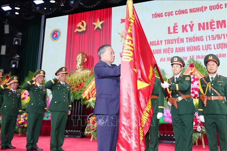 Tổng Bí thư Tô Lâm gắn huy hiệu Anh hùng Lực lượng vũ trang nhân dân lên Quân kỳ Quyết thắng của Tổng cục Công nghiệp quốc phòng, tháng 9/2025. Ảnh: TTXVN