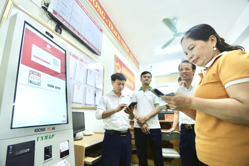 Người dân sử dụng mắt hệ thống Kiosk AI toàn trình tại khu vực Trung tâm Phục vụ hành chính công của xã Đồng Tiến. Ảnh: Ngô Nhung