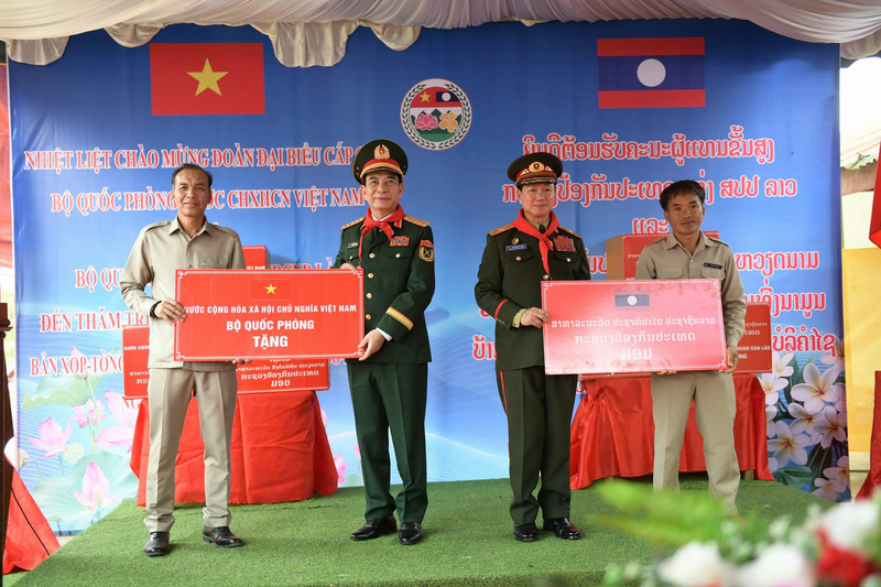 Đại tướng Phan Văn Giang và Đại tướng Khamliang Outhakaysone trao tặng nhà trường nhiều phần quà phục vụ công tác dạy và học, đồng thời trao 100 suất học bổng cho học sinh có hoàn cảnh khó khăn. Ảnh: Nam Trần