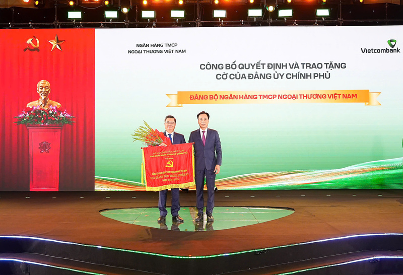 Chủ tịch HĐQT Vietcombank đại diện Đảng bộ ngân hàng đón nhận cờ thi đua của Đảng ủy Chính phủ vì đã có thành tích trong nhiệm kỳ 5 năm 2020 - 2025. Ảnh: DNCC