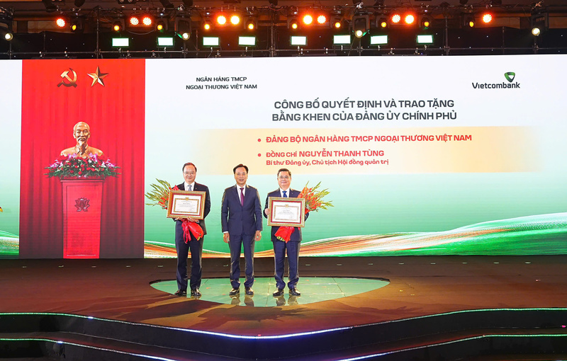 Đại diện Đảng ủy Chính phủ trao bằng khen của Đảng ủy Chính phủ tặng Đảng bộ Vietcombank vì đã có thành tích xuất sắc, tiêu biểu hoàn thành vượt mức các chỉ tiêu Nghị quyết Đại hội nhiệm kỳ 2020 - 2025 và tặng bằng khen cho cá nhân ông Nguyễn Thanh Tùng, Chủ tịch HĐQT Vietcombank vì những thành tích xuất sắc trong thực hiện Nghị quyết Đại hội nhiệm kỳ 2020 - 2025.  Ảnh: DNCC