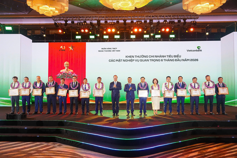 Lãnh đạo Vietcombank tặng giấy khen và trao hoa chúc mừng cho 15 chi nhánh tiêu biểu trong hoạt động kinh doanh 6 tháng đầu năm 2026. Ảnh: DNCC