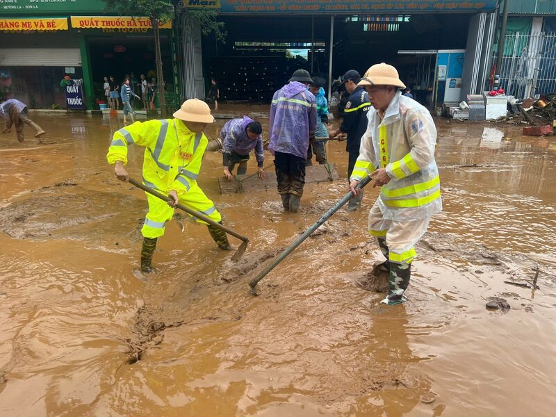 Lực lượng Cảnh sát giao thông nạo bùn, khơi thông cống rãnh do mưa lớn kéo dài. Ảnh: Công an tỉnh Sơn La