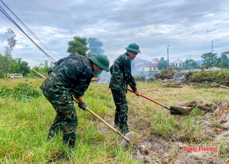 Bóc từng lớp đất nhẹ nhàng, tỉ mỉ, phía xa là chiếc xe cứu thương đang chờ sẵn để thực hiện nhiệm vụ của mình.