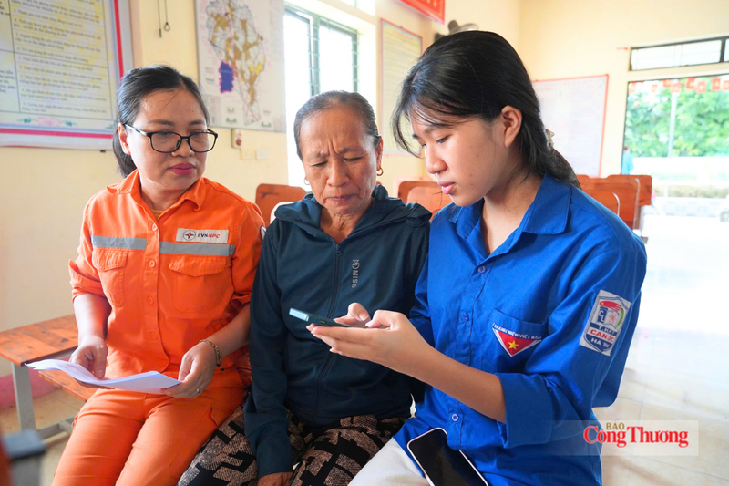 Nhân viên Công ty Điện lực Hà Tĩnh phối hợp chính quyền địa phương hỗ trợ người dân cài đặt EVN CSKH. Ảnh: Cao Thảo
