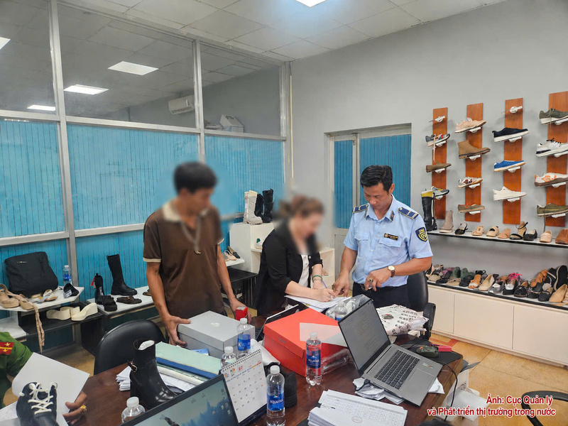 Cán bộ Cục Quản lý và Phát triển thị trường trong nước kiểm tra, phát hiện hàng hàng loạt đôi giày có dấu hiệu giả mạo nhãn hiệu Nike.