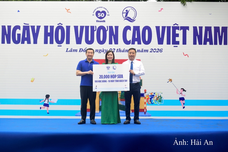 Đại diện Quỹ sữa Vươn cao Việt Nam, ông Đỗ Thanh Tuấn - Giám đốc Đối ngoại Vinamilk (bên trái) và ông Đinh Tiến Hải - Giám đốc Quỹ Bảo trợ Trẻ em Việt Nam trao bảng tượng trưng các phần quà thiết thực cho đại diện Trường Tiểu học An Hiệp, xã Hiệp Thạnh