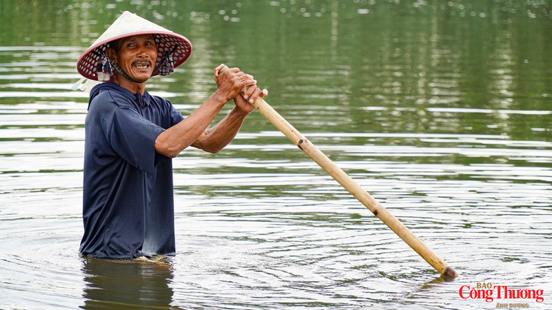 Với một dây đai được quấn quanh hông, người dân đi lùi về phía sau để cào những con don vùi mình trong cát
