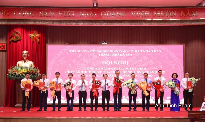 Phó Bí thư Thường trực Thành ủy Hà Nội Nguyễn Trọng Đông và Chủ tịch UBND TP. Hà Nội Vũ Đại Thắng trao quyết định về công tác cán bộ tại hội nghị.
