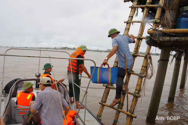 Cán bộ, chiến sĩ Bộ đội Biên phòng tỉnh Ninh Bình tuyên truyền, hướng dẫn ngư dân bảo đảm an toàn khi hoạt động trên biển. Ảnh: Minh Khôi.