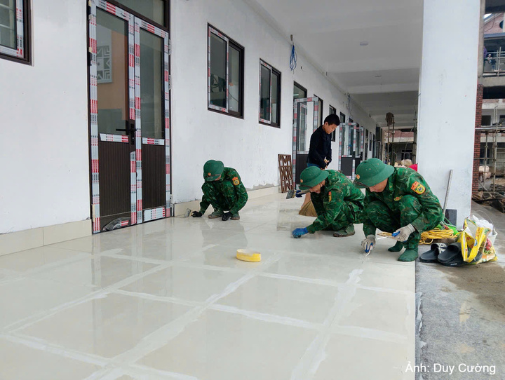 Cán bộ, chiến sĩ Đồn Biên phòng Tả Gia Khâu tham gia vệ sinh, hoàn thiện các hạng mục tại Trường Phổ thông dân tộc nội trú Tiểu học và Trung học cơ sở Pha Long, góp phần đưa công trình về đích đúng tiến độ.