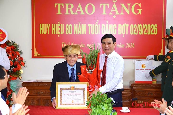 Đại tướng Phan Văn Giang trao Huy hiệu 80 năm tuổi Đảng và tặng hoa chúc mừng đồng chí Nguyễn Quang Nam.
