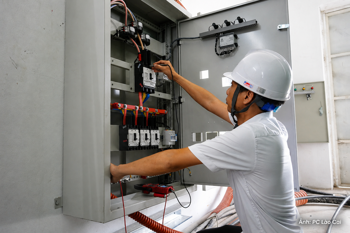 Chuyên viên tiến hành đo đạc, kiểm tra thông số kỹ thuật tại tủ điều khiển inverter, bảo đảm an toàn cho hệ thống điện tự sản xuất, tự tiêu thụ. Ảnh: PC Lào Cai