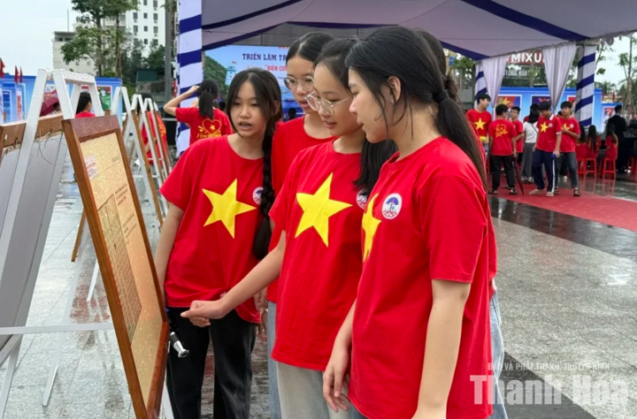 Các em học sinh hào hứng xem những tranh cổ động và ảnh tư liệu "Biên cương vững bền - Biển đảo thiêng liêng".