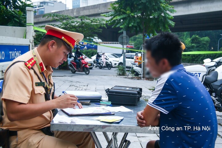 Lực lượng Cảnh sát giao thông lập biên bản xử phạt trường hợp vi phạm kinh doanh vận tải theo quy định.