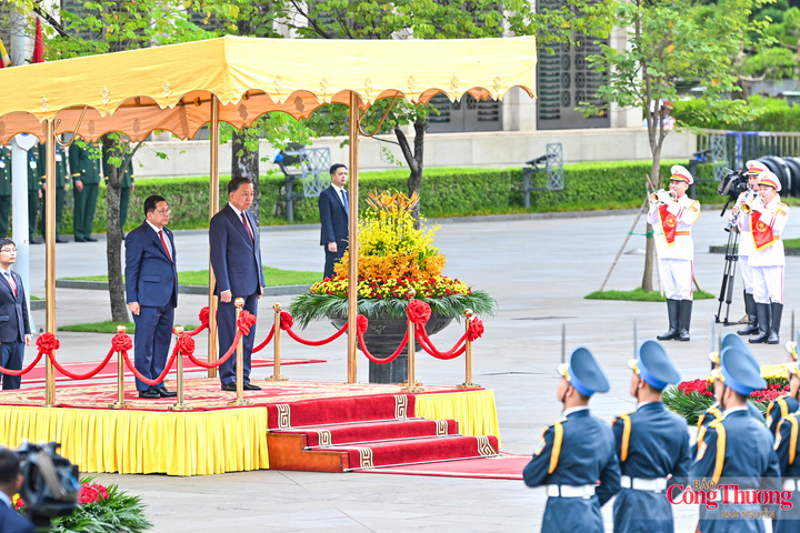 Hai nhà lãnh đạo cùng bước lên bục danh dự. Quân nhạc lần lượt cử quốc thiều hai nước.