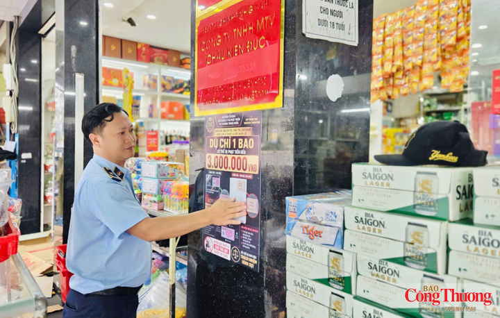 Lực lượng quản lý thị trường dán cam kết tuyên truyền trong kinh doanh thuốc lá tại các cơ sở kinh doanh trên địa bàn phường Diên Hồng.