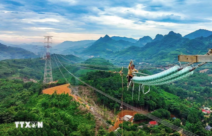 Công nhân ngành điện triển khai kéo cáp dây điện trên vị trí cột số 18,17 của dự án đường dây 500kV, thuộc xã Xuân Quang, tỉnh Lào Cai. Ảnh: Vũ Sinh/TTXVN