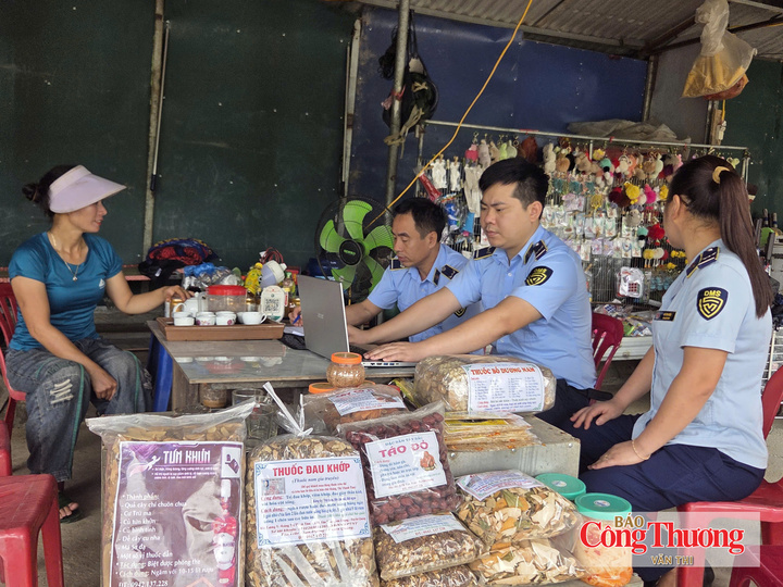 Cán bộ Quản lý thị trường Tuyên Quang tuyên truyền, hướng dẫn hộ kinh doanh ký cam kết chấp hành quy định pháp luật.