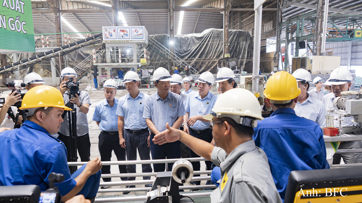 Các đại biểu tìm hiểu quá trình kích hoạt mã định danh trên từng bao phân bón tại dây chuyền sản xuất.