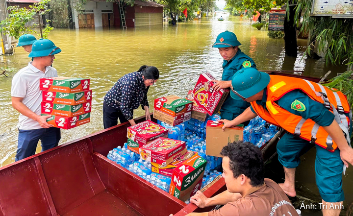 Tại một số khu vực, cán bộ, chiến sĩ lội trong những căn nhà còn ngập nước để thu gom nông sản; cùng người dân vận chuyển mì ăn liền, nước uống và nhu yếu phẩm.