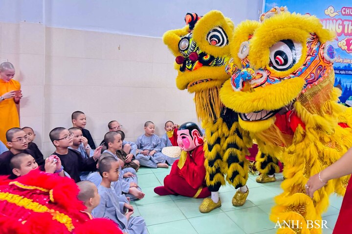 Các em nhỏ thích thú trêu đùa với những chú lân. Ảnh: BSR
