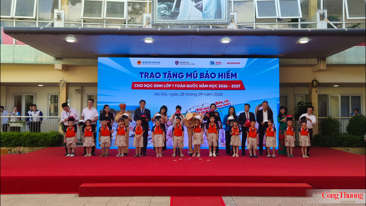 Các đại biểu trao mũ bảo hiểm cho các em học sinh.