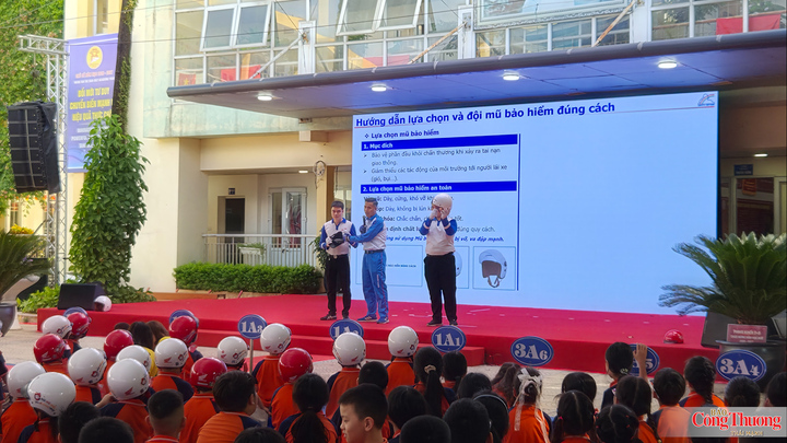 Các em học sinh thích thú khi được hướng dẫn lựa chọn và đội mũ bảo hiểm đúng cách.