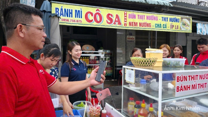 Các lực lượng chức năng phường An Xuyên (tỉnh Cà Mau) ra quân hướng dẫn các tiểu thương hình thức thanh toán không dùng tiền mặt.