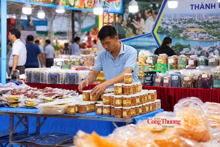 Người bán hàng sắp xếp muối tôm Tây Ninh, sẵn sàng phục vụ khách tham quan, mua sắm tại hội chợ.