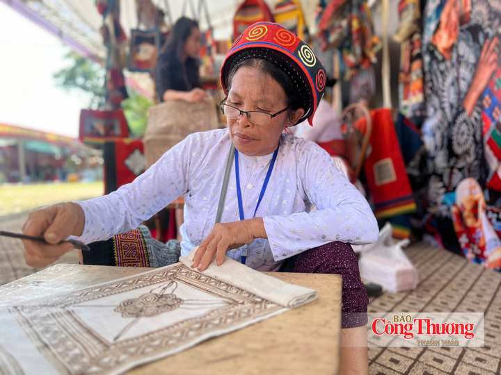 Bà Hạ Thị Thỏ thực hiện công đoạn vẽ hoa văn trên vải bằng sáp ong.