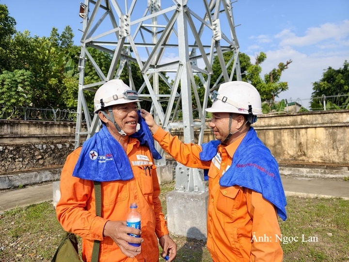 Nhân viên Công ty Điện lực Quảng Ninh hỏi thăm, động viên đồng nghiệp vừa hoàn thành phiên công tác trên cao.