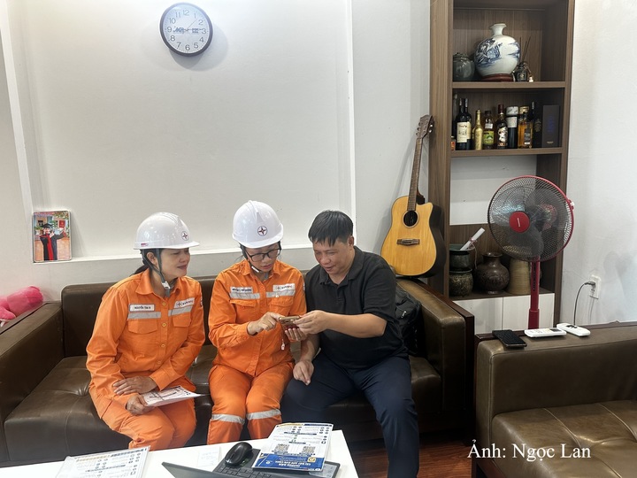Nhân viên Điện lực Hạ Long hướng dẫn khách hàng cài đặt ứng dụng EVN chăm sóc khách hàng.