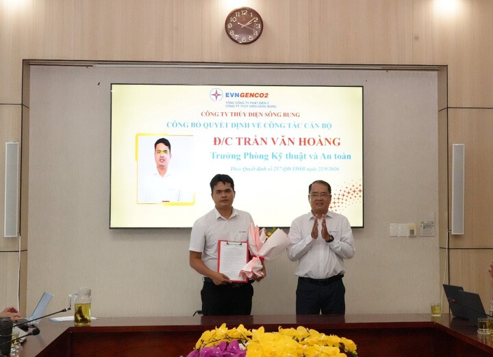 Ông Nguyễn Thành Trung – Bí thư Đảng ủy, giám đốc Công ty trao quyết định và tặng hoa chúc mừng đồng chí Trần Văn Hoàng