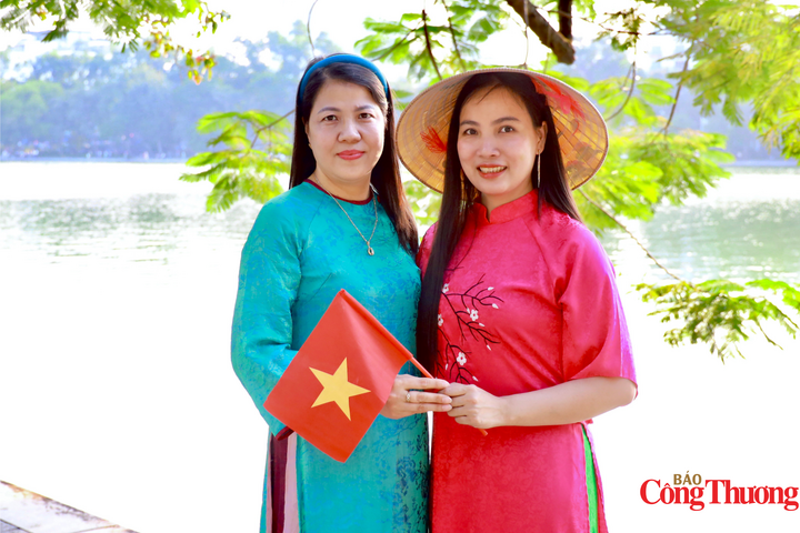 Chị Tố Uyên (32 tuổi, bên phải) cùng bạn rạng rỡ trong tà áo dài truyền thống, chụp ảnh lưu niệm cùng lá cờ Tổ quốc bên hồ Hoàn Kiếm nhân dịp kỷ niệm Ngày Giải phóng Thủ đô. Chị chia sẻ: “Nhân dịp ngày kỷ niệm, mình và bạn rủ nhau diện áo dài ra phố chụp hình. Việc ghi lại những khoảnh khắc đẹp này vừa là niềm vui cá nhân, vừa là cách thể hiện tình yêu với Hà Nội”. Ảnh: Thanh Huyền