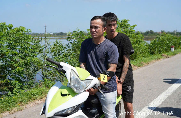 Hai đối tượng Nguyễn Công Bình (ngồi trước) và đối tượng Trần Lợi thực nghiệm tại hiện trường vụ cướp
